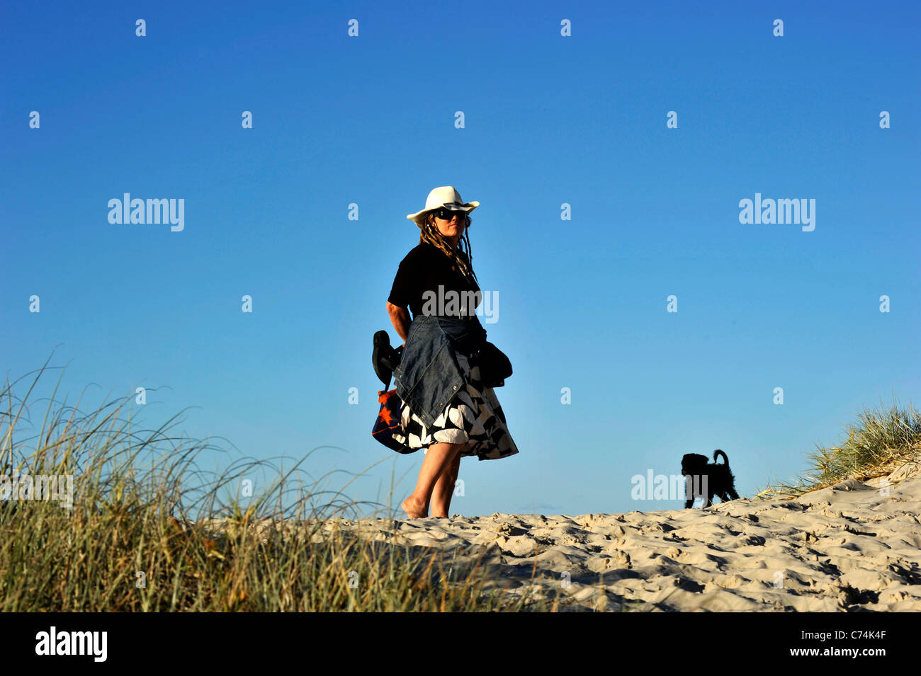 Una donna con un cucciolo sulla spiaggia Foto Stock