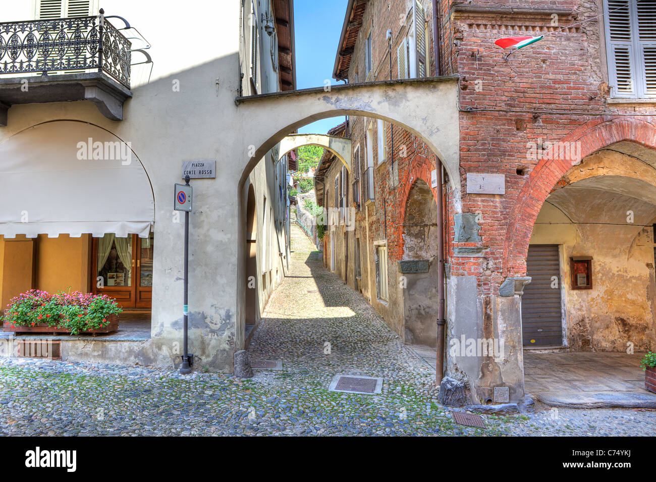 Strette strade lastricate lungo vintage case di mattoni nella città di Avigliana, Italia settentrionale. Foto Stock