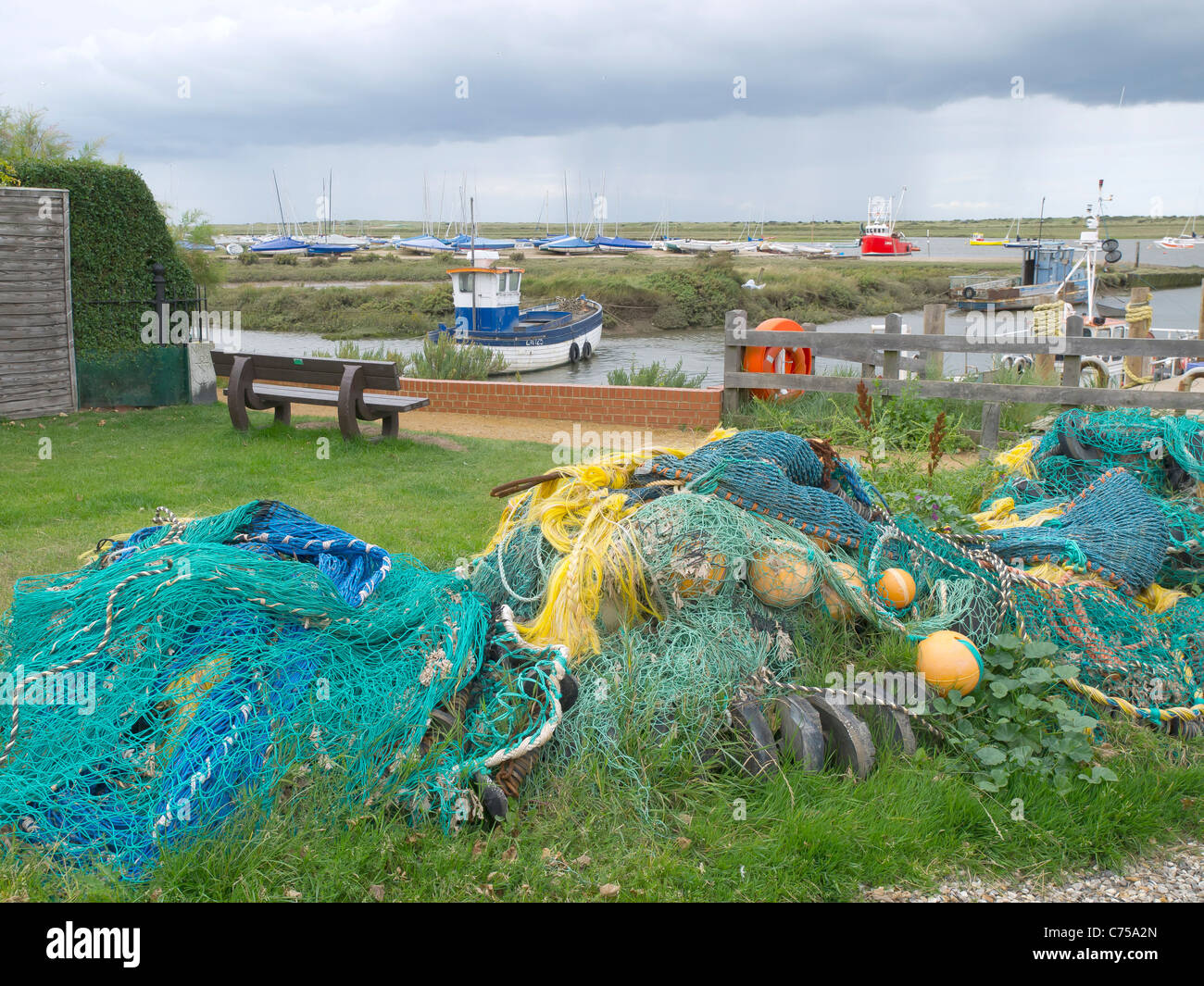Le reti da pesca e galleggianti impilati davanti al porto a Brancaster Staithe Norfolk Foto Stock