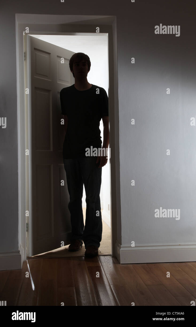 Silhouette di un uomo di entrare in una stanza buia. Foto Stock