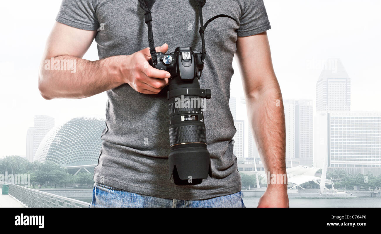 L'uomo holdin fotocamera e sfondo di Singapore Foto Stock