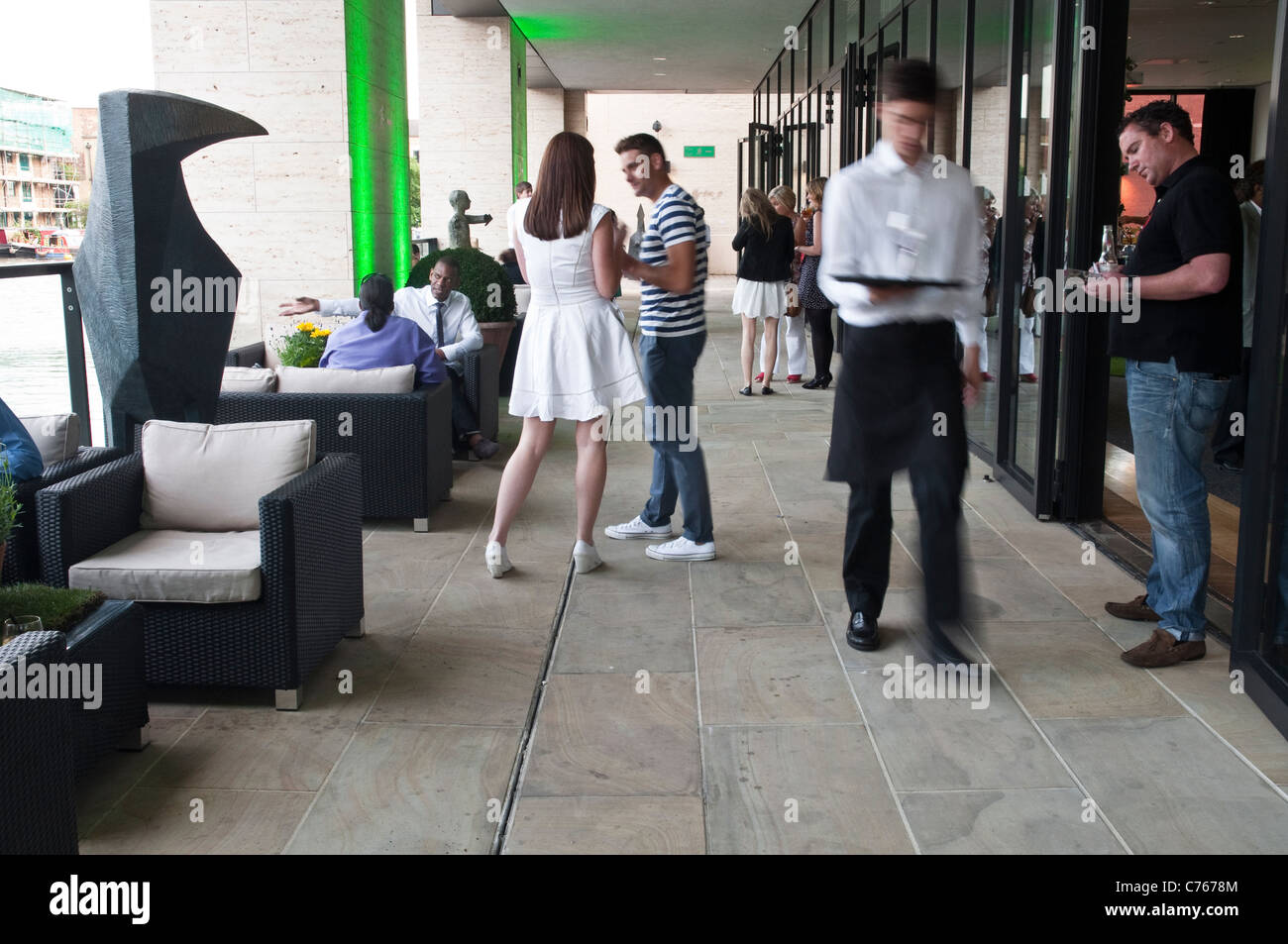 Amici e colleghi gustando drinks del dopo lavoro sulla terrazza esterna al Kings Place Arts/ufficio complesso, a nord di Londra. Foto Stock