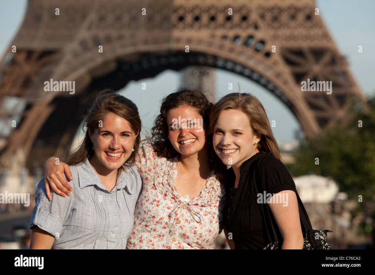 Francia, Parigi, ritratto di tre giovani donne davanti alla Torre Eiffel Foto Stock