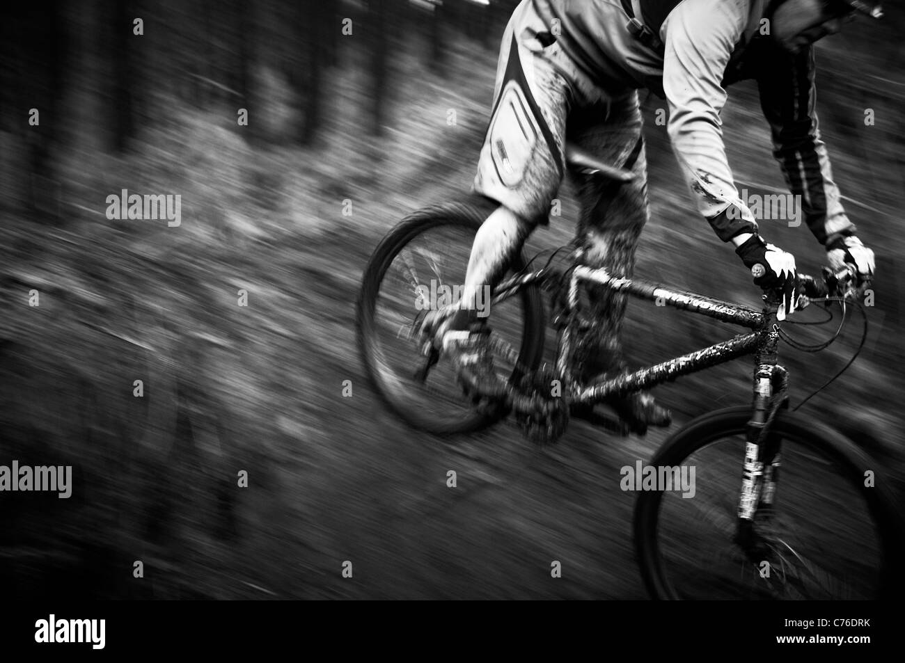 Coperti di fango in mountain bike e pilota sul binario unico in bianco e nero Foto Stock