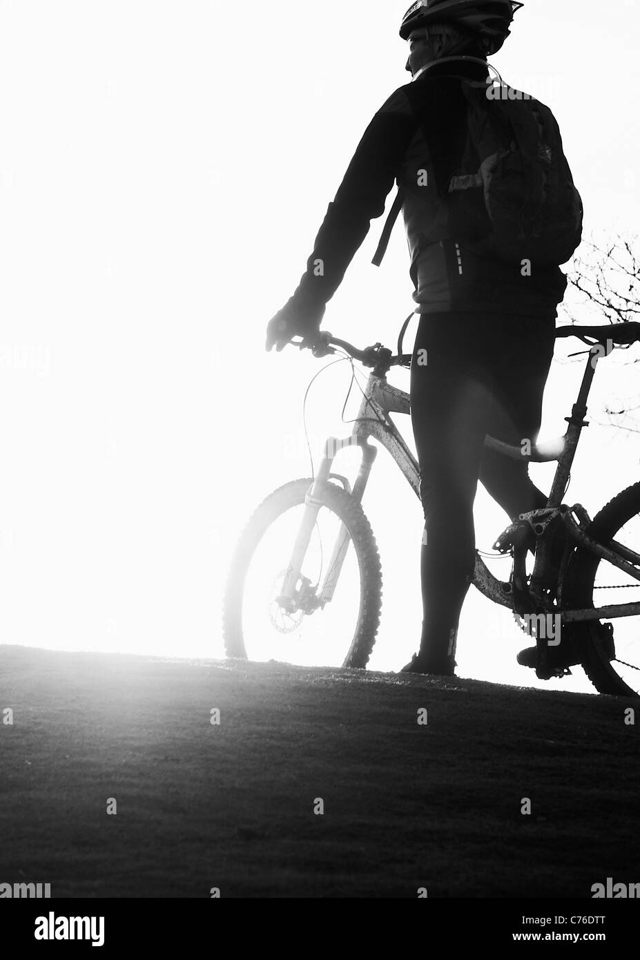 Silhouette di tre mountain biker in set di Sun Foto Stock