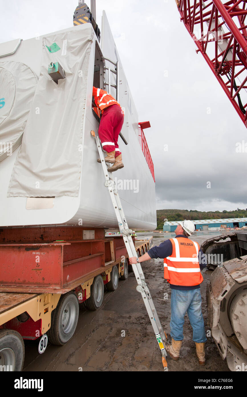 I lavoratori di sollevare una navicella per una turbina eolica su un martinetto fino chiatta, per il Walney offshore wind farm. Foto Stock