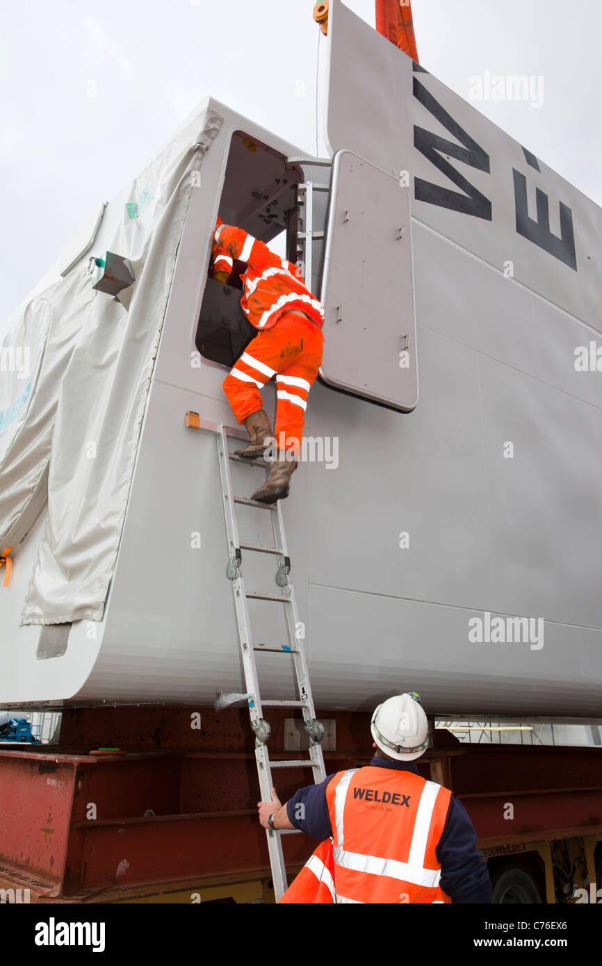 Preparare i lavoratori per il sollevamento di una navicella di una turbina eolica su un martinetto fino barge per il Walney offshore wind farm. Foto Stock