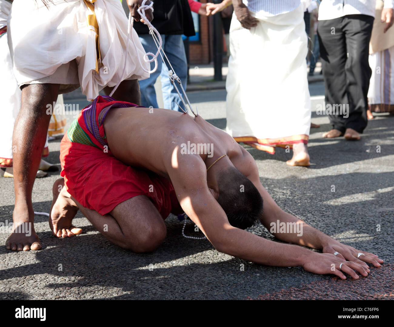 Il penitente nella processione Thaipusam, durante il carro annuale Festival, comunità Tamil Tooting, Londra Foto Stock