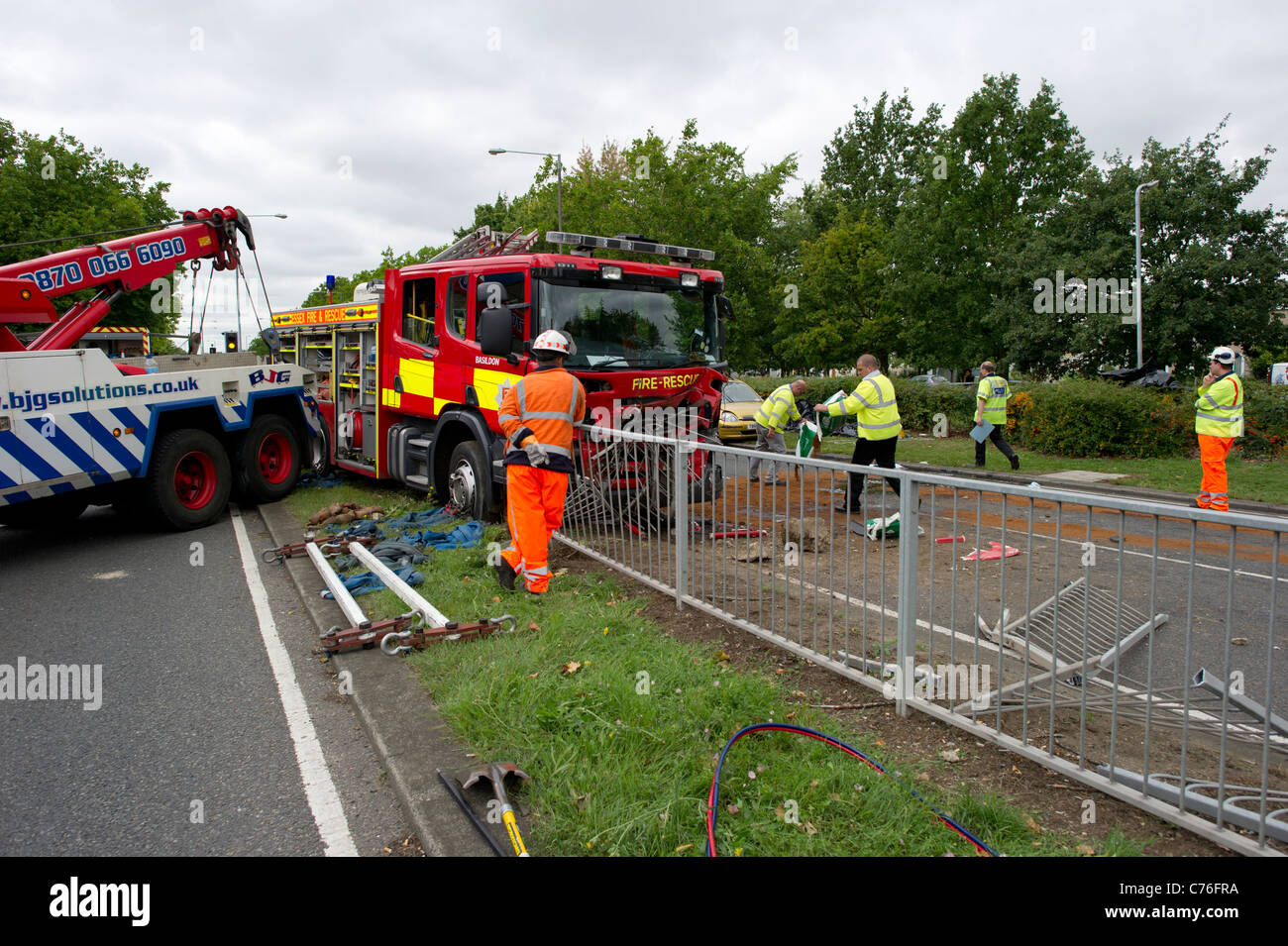 La polizia e i lavoratori di recupero preparazione per cancellare la scena di un grave incidente stradale che coinvolge un incendio del motore e di un'auto. Foto Stock