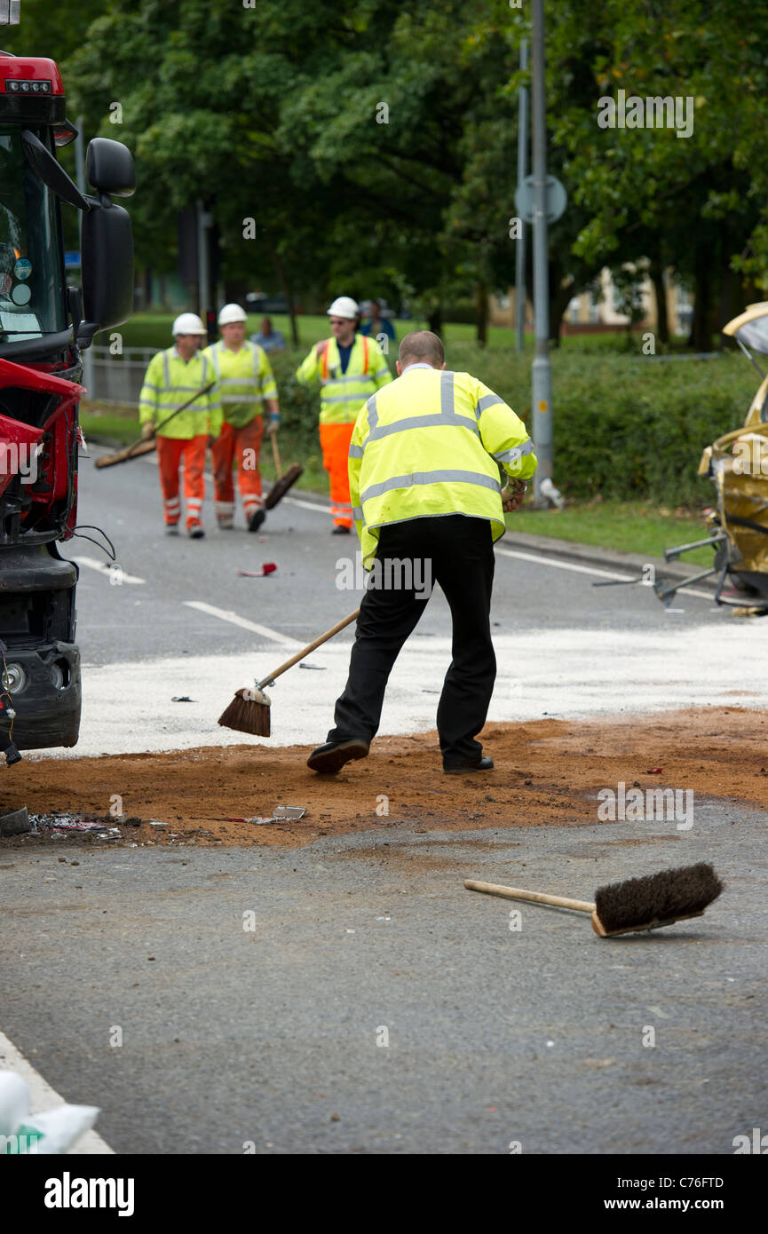 Highways Agency lavoratori deselezionando la strada alla scena di grave incidente stradale tra un incendio del motore e di un'auto. Foto Stock