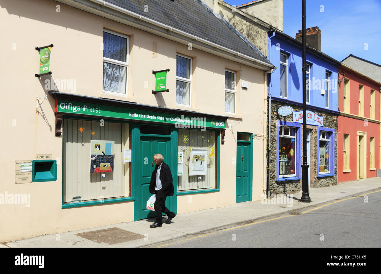 Un passante balade passato il post office in Castletownbere sulla penisola di Beara, Co Cork, Irlanda. Foto Stock