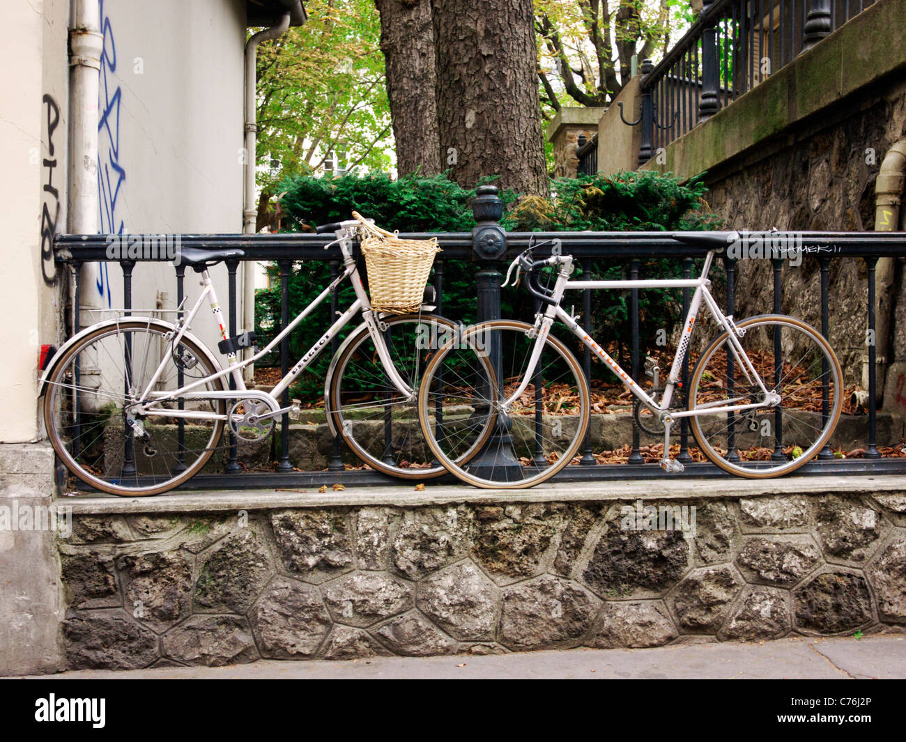 Due biciclette incatenate insieme a una recinzione Foto Stock