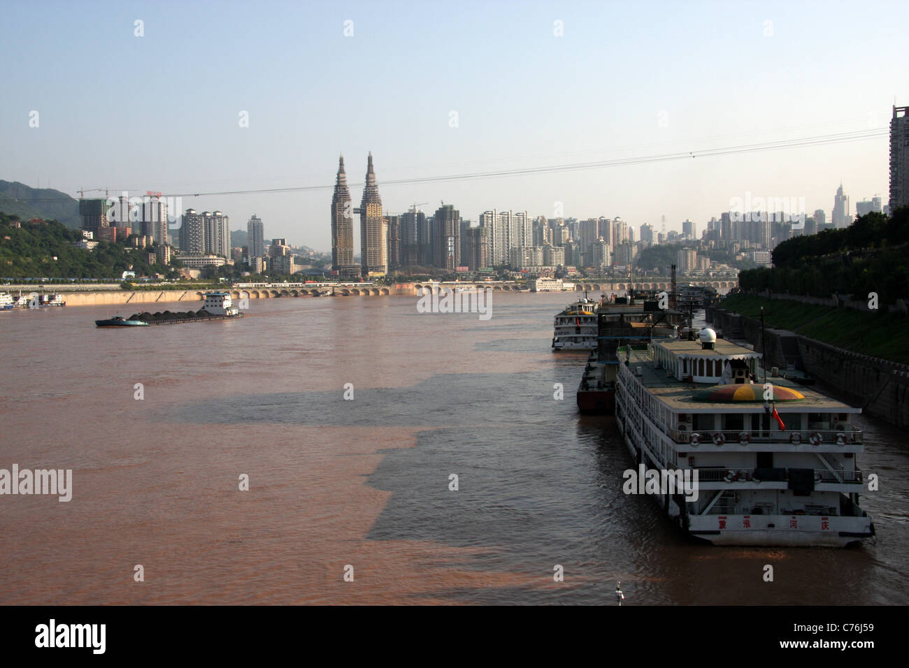Vista serale (guardando a monte) del traffico fluviale e barche ormeggiate lungo il fiume Yangtze a Chongqing Cina Foto Stock