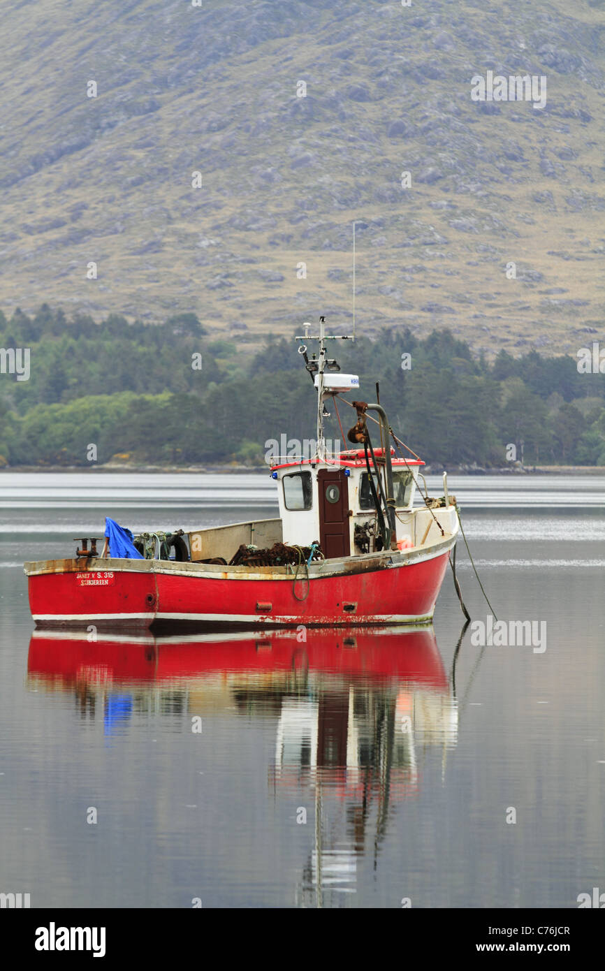 Un rosso barca da pesca in un porto naturale nei pressi del villaggio di Lauragh sulla penisola di Beara, Co Kerry, Rep dell'Irlanda. Foto Stock