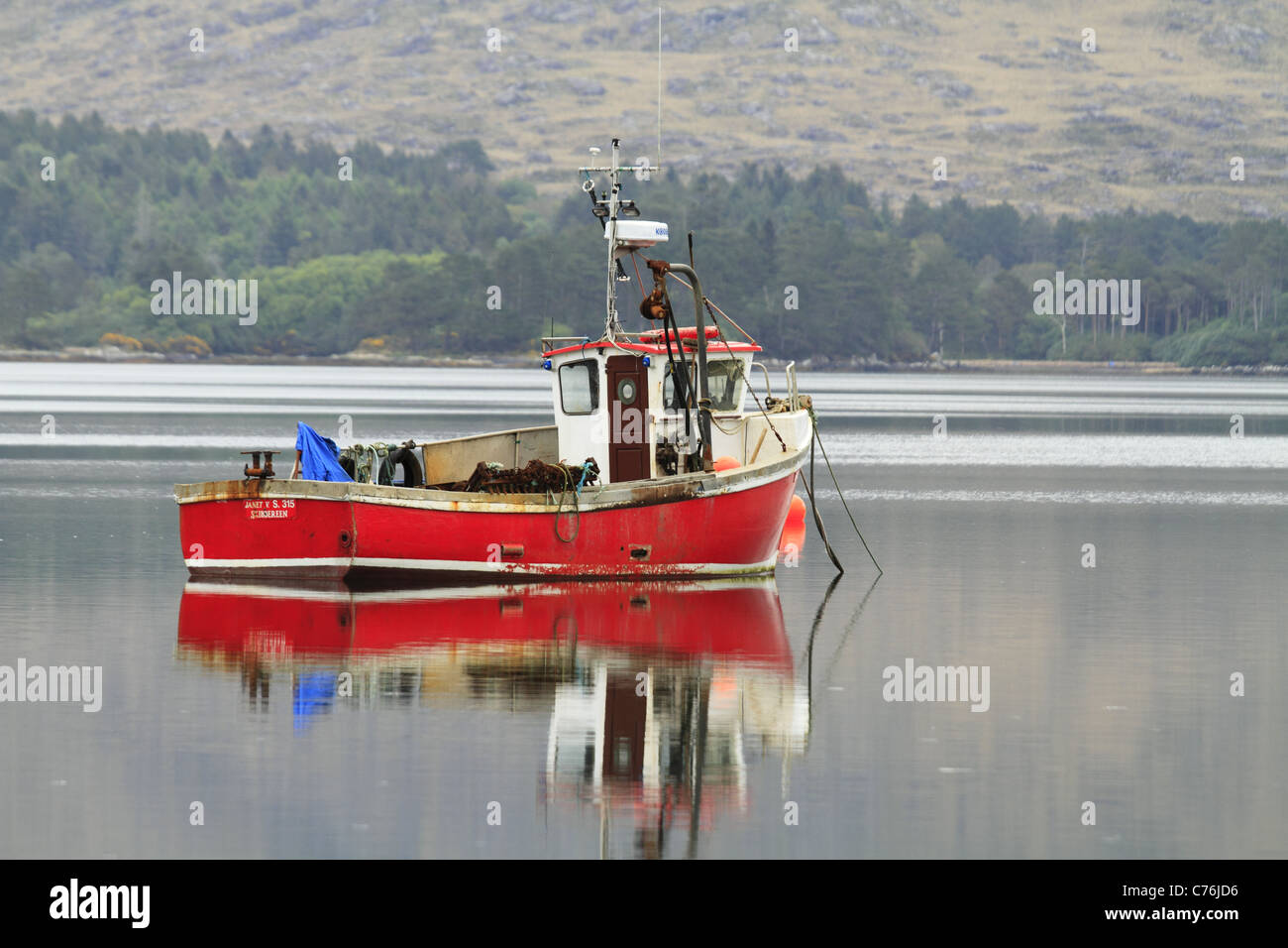 Un rosso barca da pesca in un porto naturale nei pressi del villaggio di Lauragh sulla penisola di Beara, Co Kerry, Rep dell'Irlanda. Foto Stock