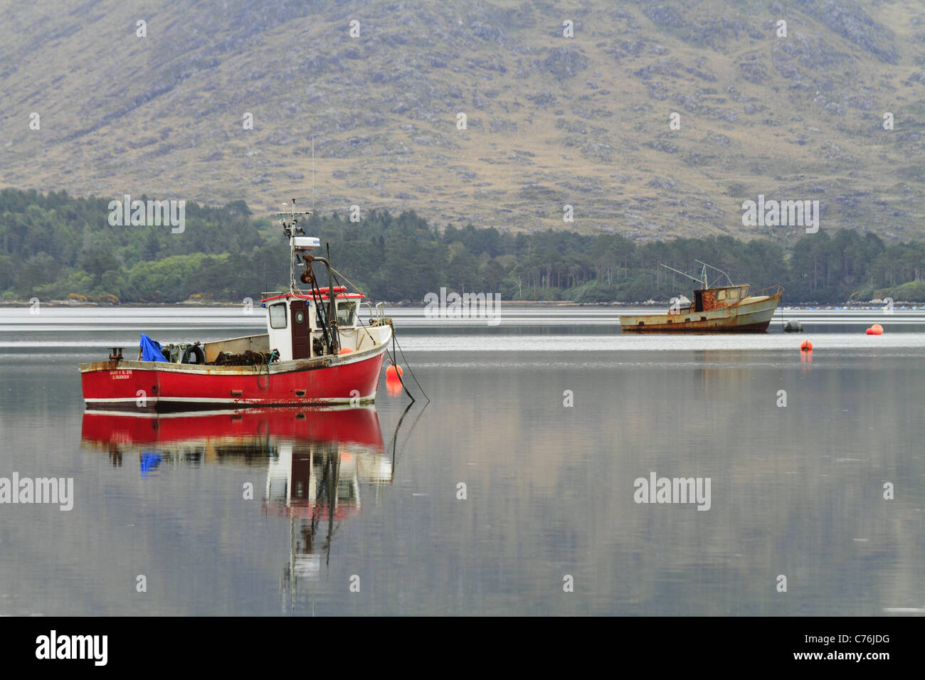 Un rosso barca da pesca in un porto naturale nei pressi del villaggio di Lauragh sulla penisola di Beara, Co Kerry, Rep dell'Irlanda. Foto Stock
