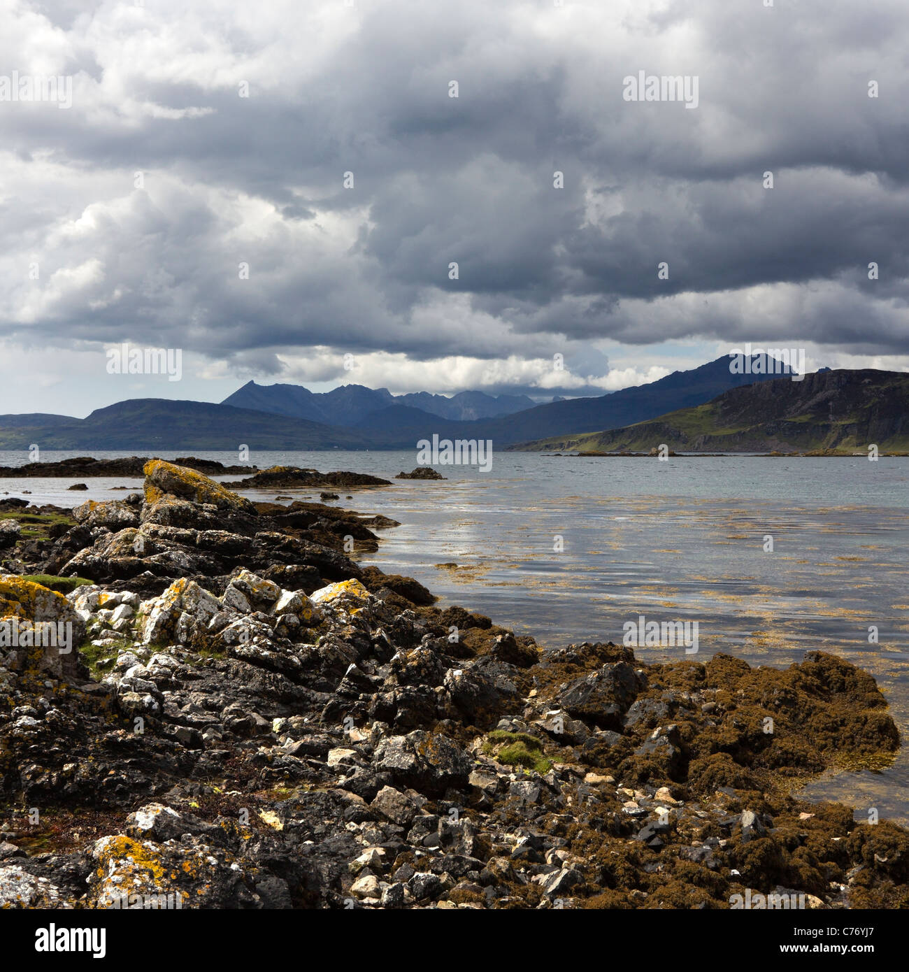 Costa rocciosa di Loch Eishort con Nero montagne Cuillin oltre, Ord, Isola di Skye, Scotland, Regno Unito Foto Stock