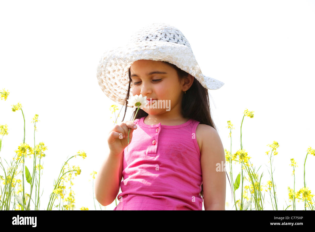 Ragazza giovane odorare un fiore Foto Stock