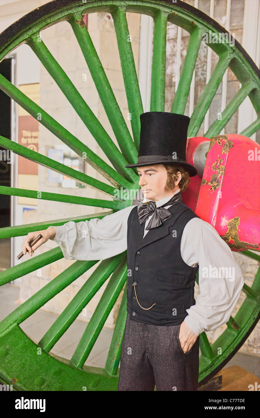 La figura che rappresenta Isambard Kingdom Brunel accanto a una gigantesca ruota ferroviaria in STEAM museum in Swindon Regno Unito Foto Stock