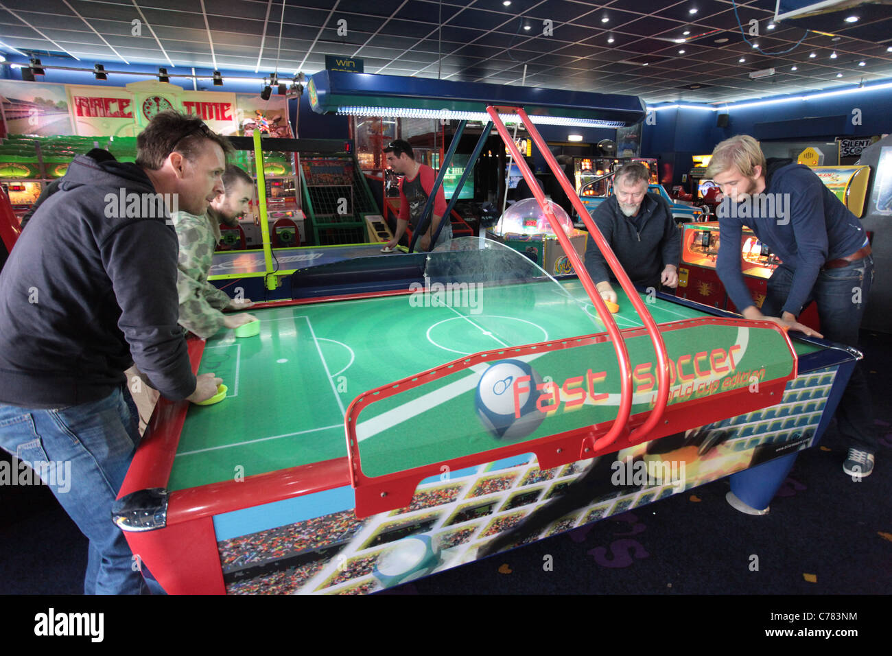 Gli uomini che giocano a air hockey gioco arcade Foto Stock