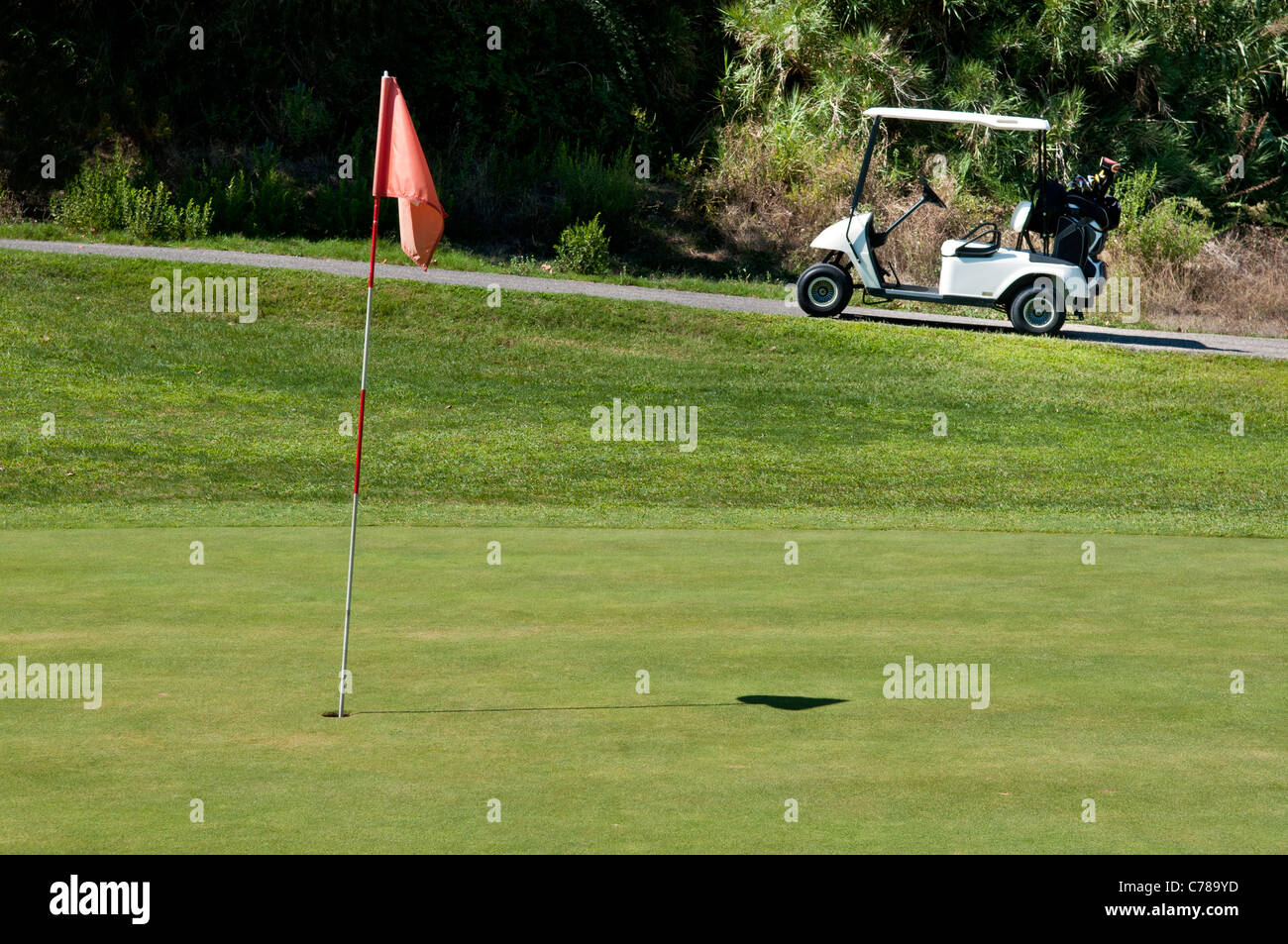 Carrello da golf accanto a un foro su un campo da golf Foto Stock