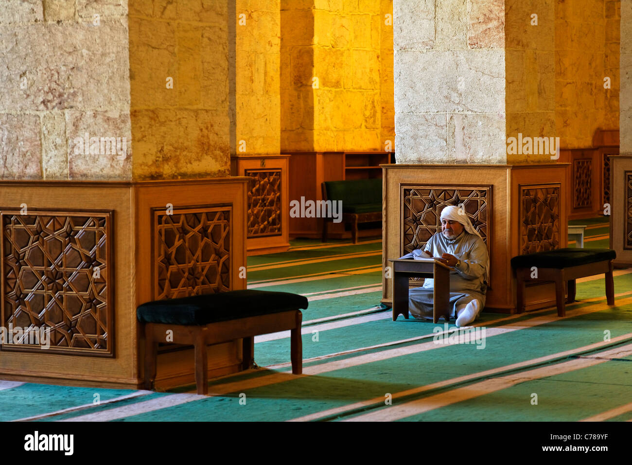 L'uomo la lettura del Corano dentro la grande moschea di Aleppo, Siria Foto Stock
