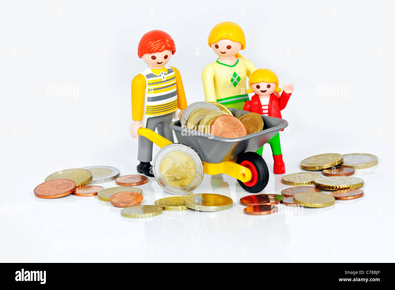 Assegno per figli a carico - Playmobil famiglia e una carriola riempito con le monete in euro. Foto Stock