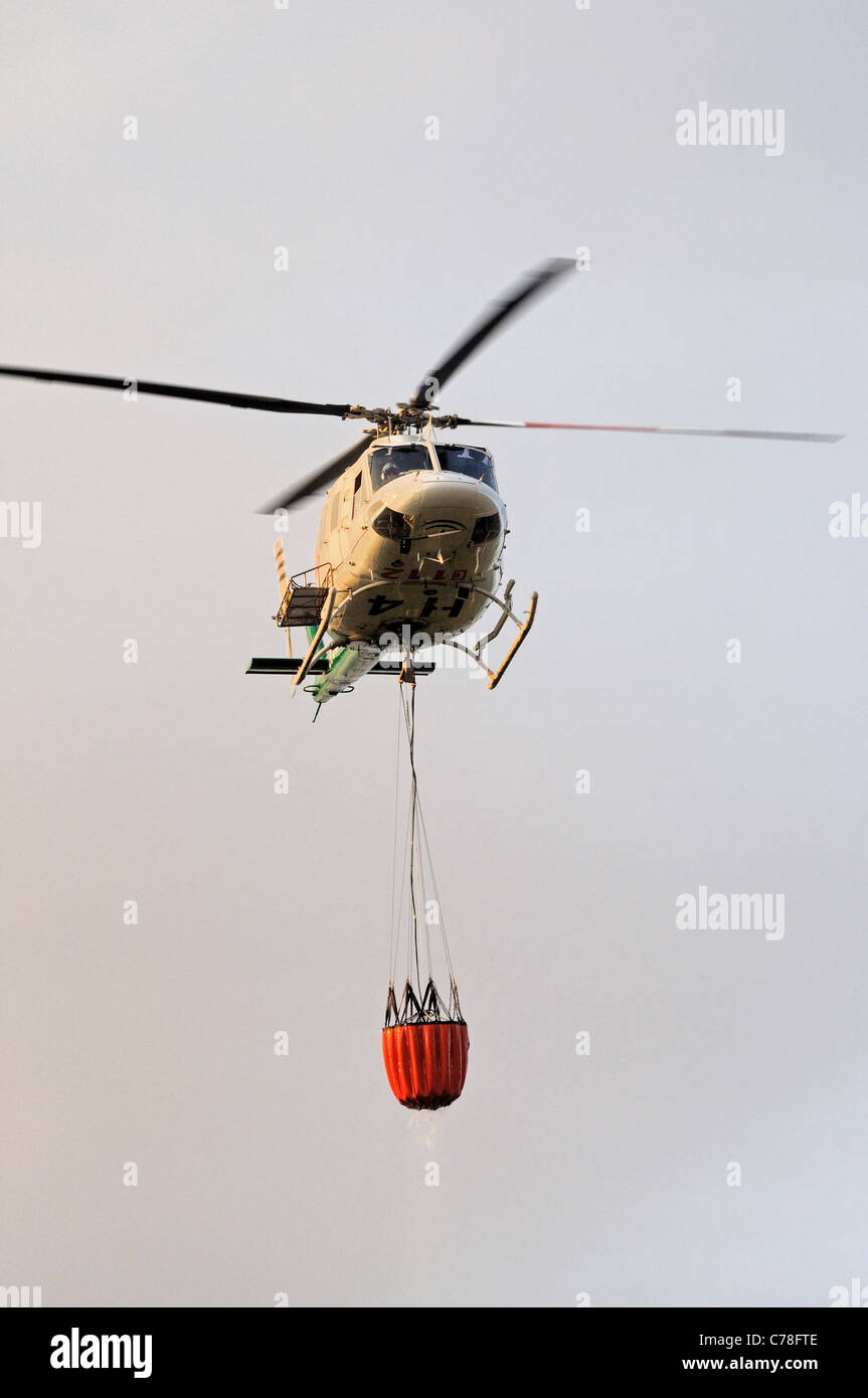 Bell 412 elicottero (registrazione CE-IPM) portando acqua, Cabopino Golf, Costa del Sol, provincia di Malaga, Andalusia. Foto Stock