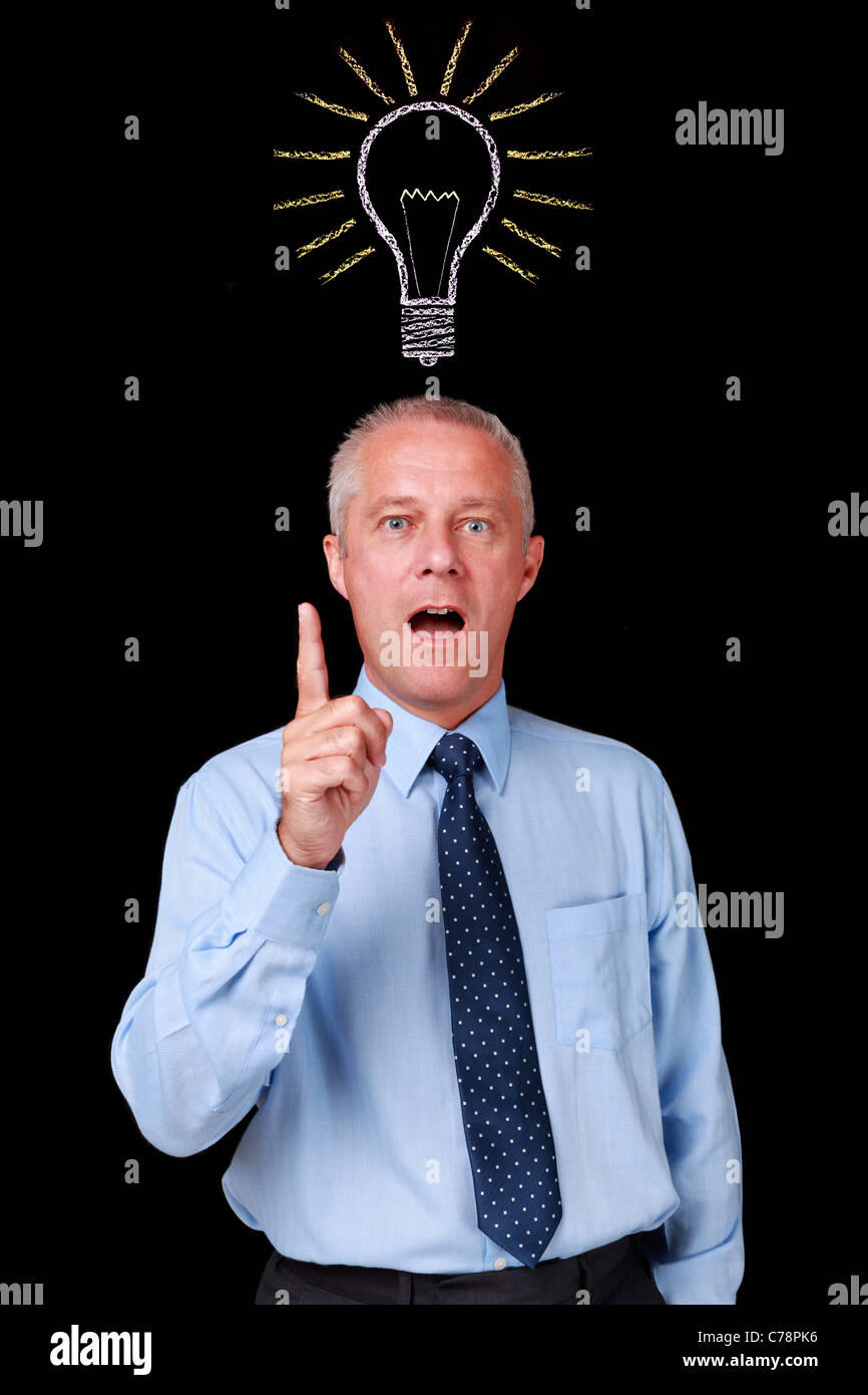 Foto di un imprenditore maturo contro uno sfondo nero con un gesso lampadina disegnato sopra la sua testa Foto Stock