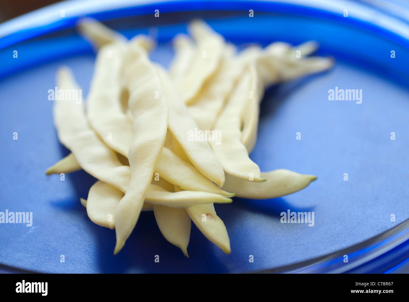 Fagiolini su una piastra di colore blu Foto Stock