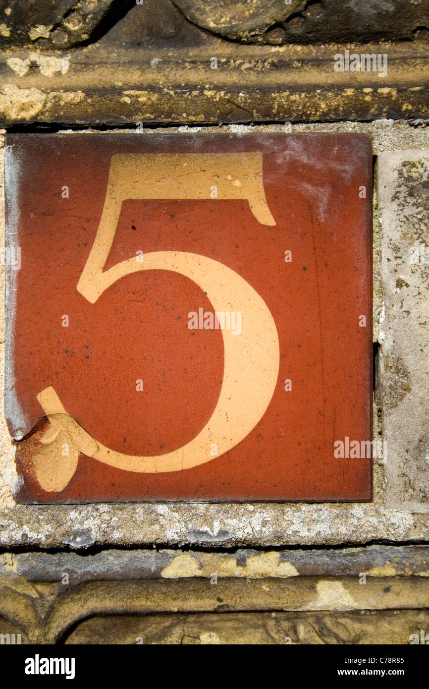 Un Vittoriano piastrelle di terracotta che mostra un numero cinque. Foto Stock