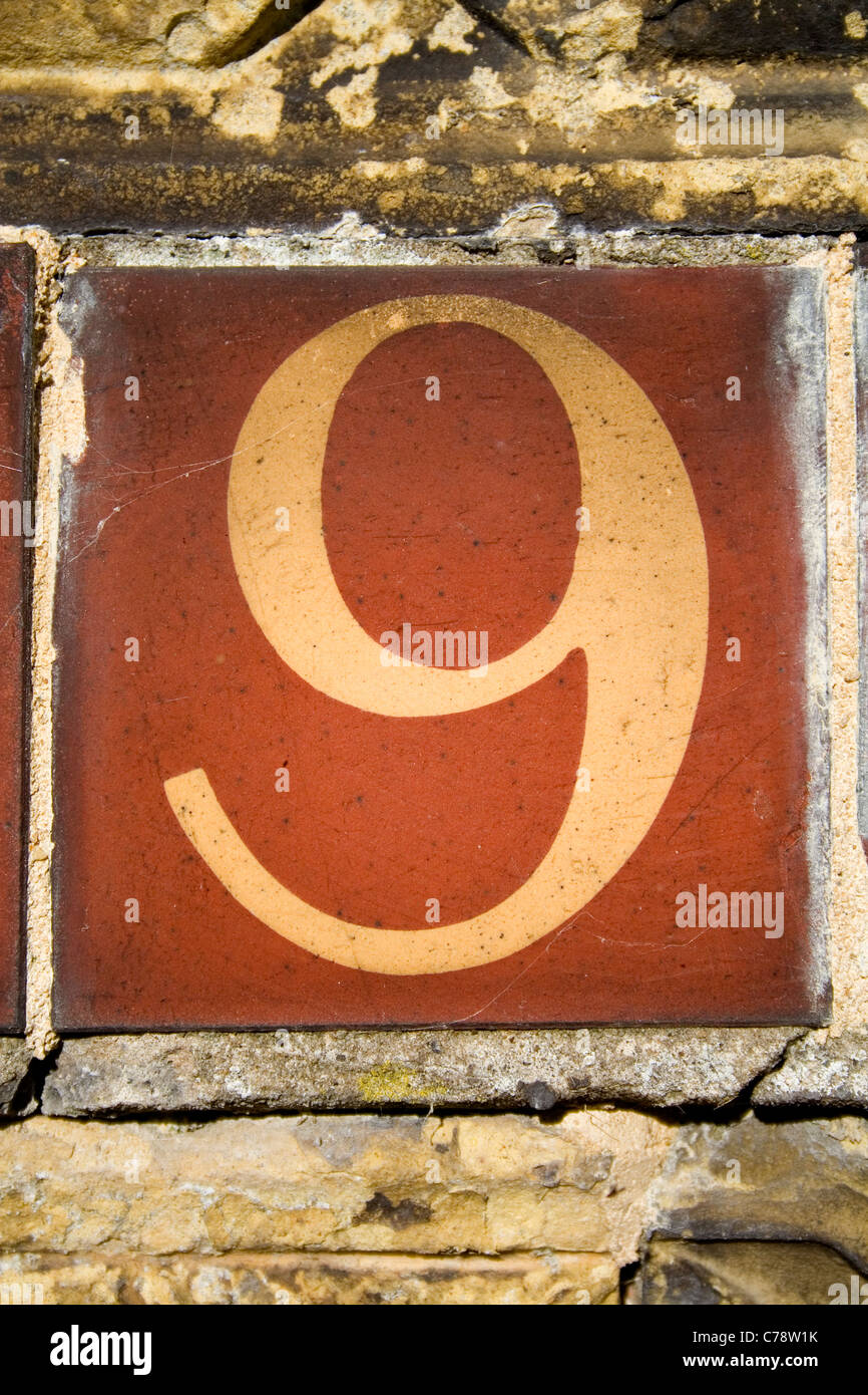 Un Vittoriano piastrelle di terracotta recanti il numero nove. Foto Stock
