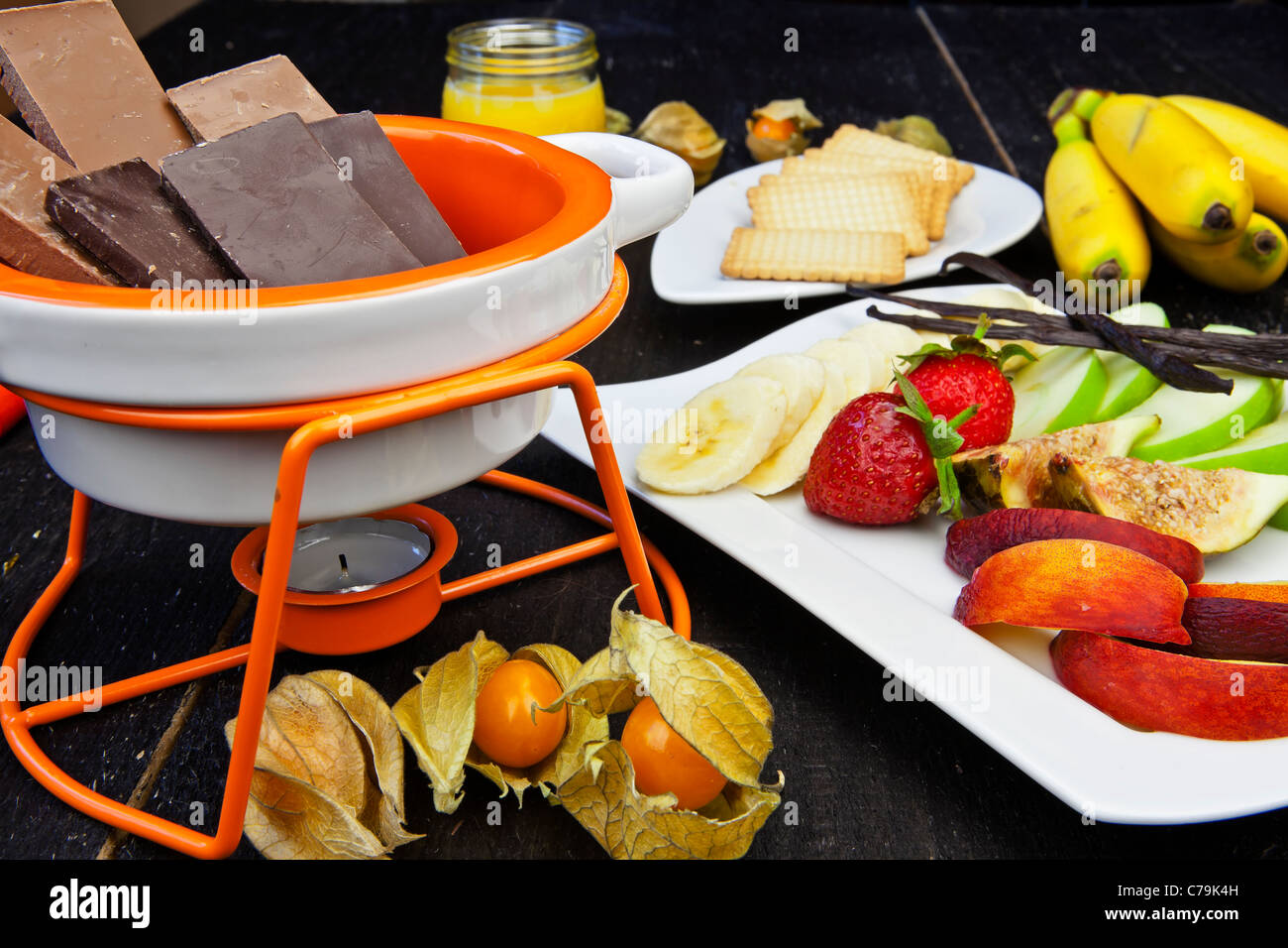 Gli ingredienti freschi per un tipico Svizzero la fonduta di cioccolato con frutta e biscotti Foto Stock