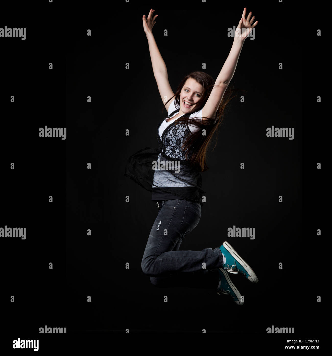 Studio shot della ragazza adolescente (14-15) jumping Foto Stock