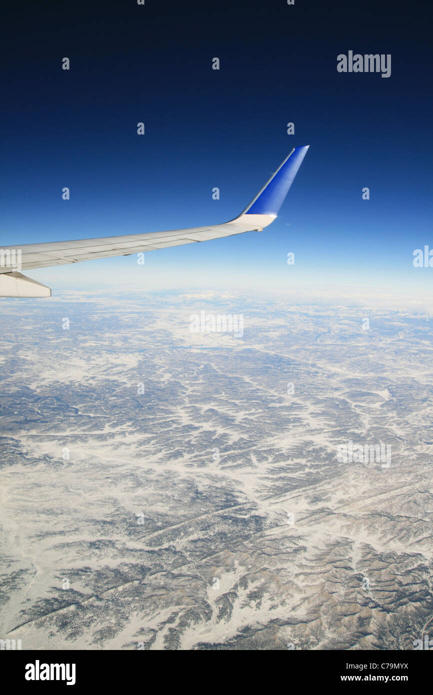 Vista da un aereo in volo su montagne invernali con la compagnia aerea ala visibile Foto Stock