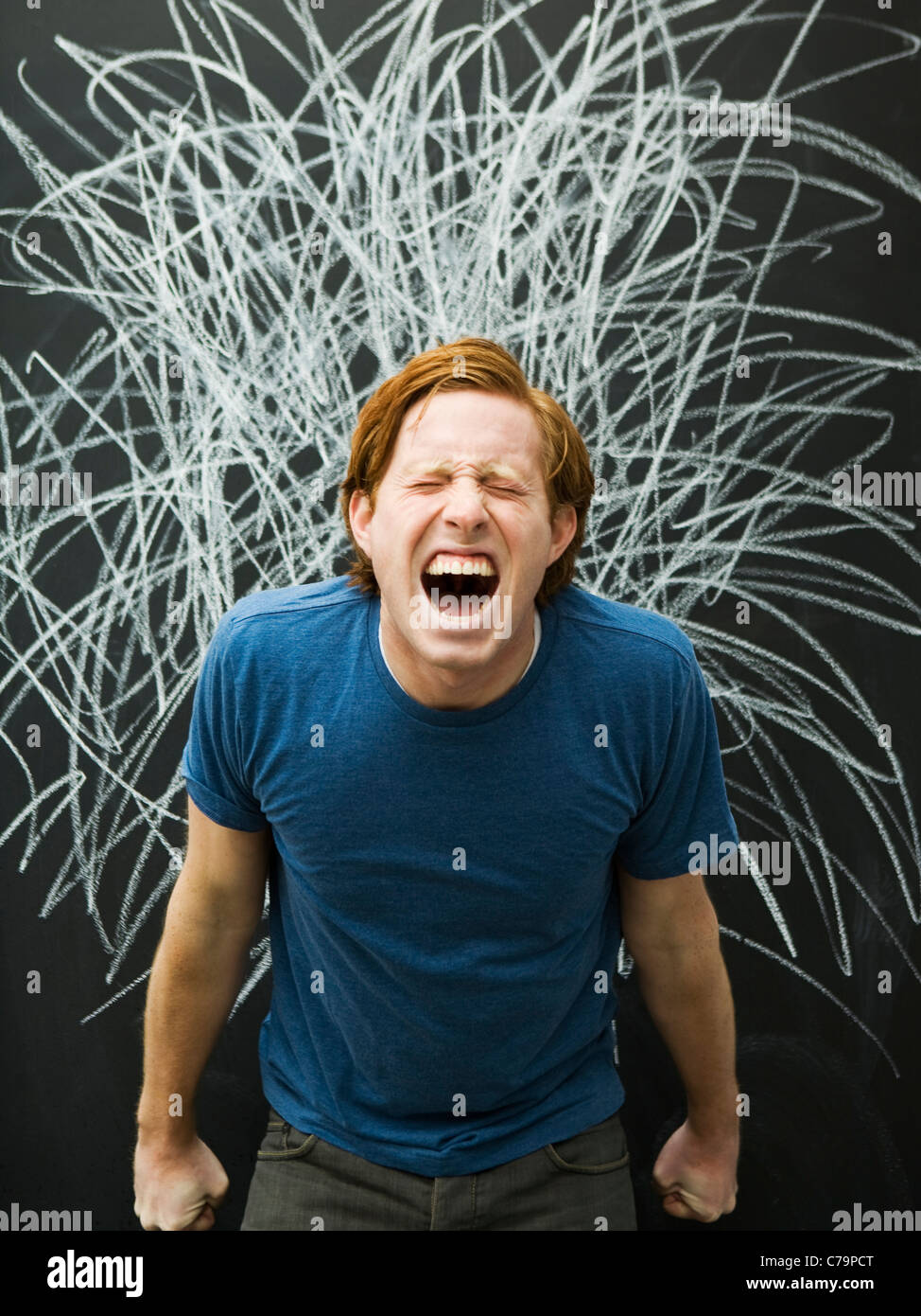 Studio shot dell'uomo urla con chalk scribble sulla lavagna Foto Stock