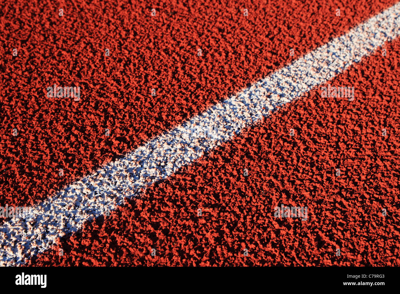 Dettaglio del diagonal linea bianca su una gomma rossa superficie di traccia Foto Stock