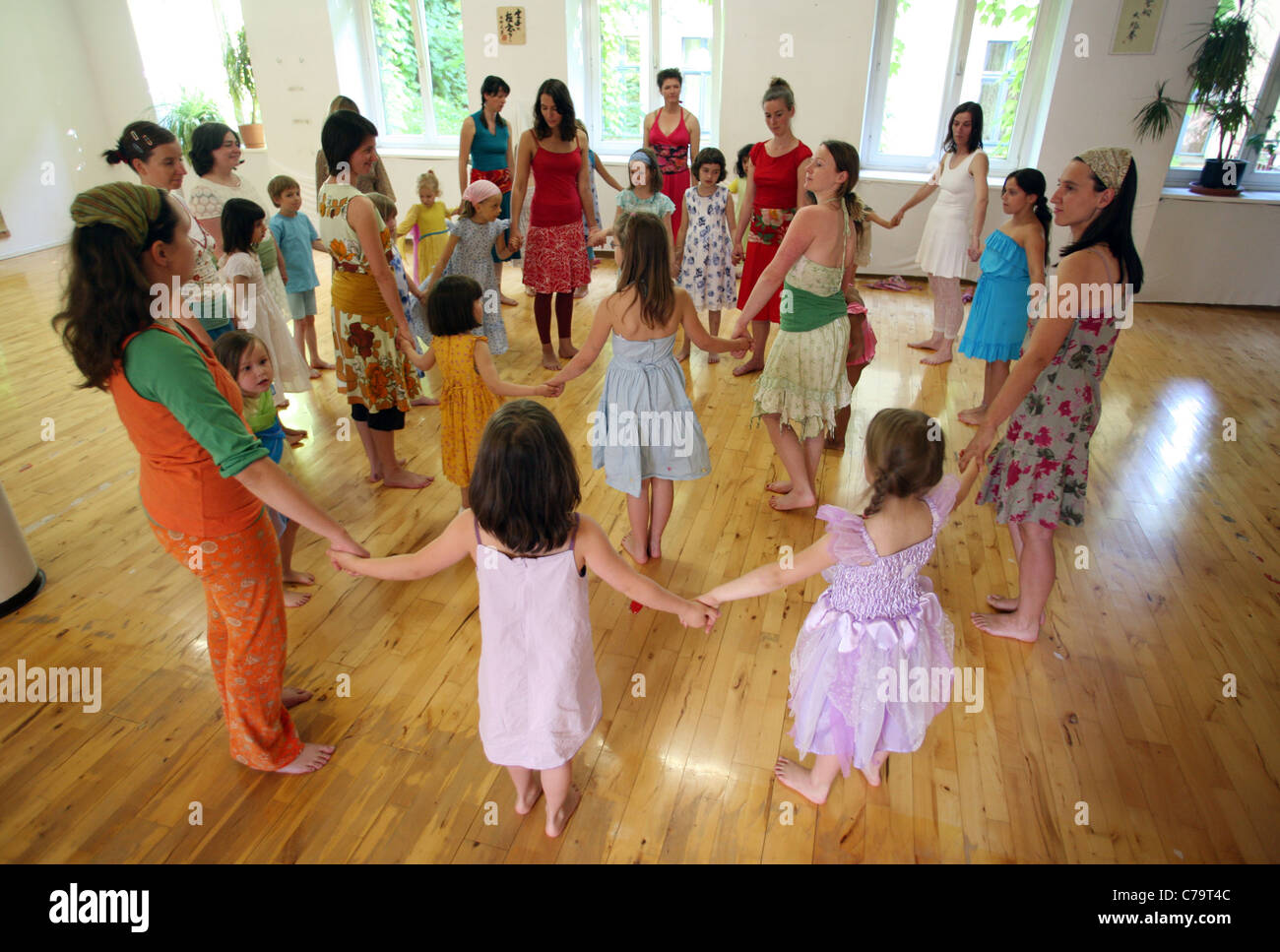 Le donne e i bambini in piedi in cerchio, tenendo le mani Foto Stock