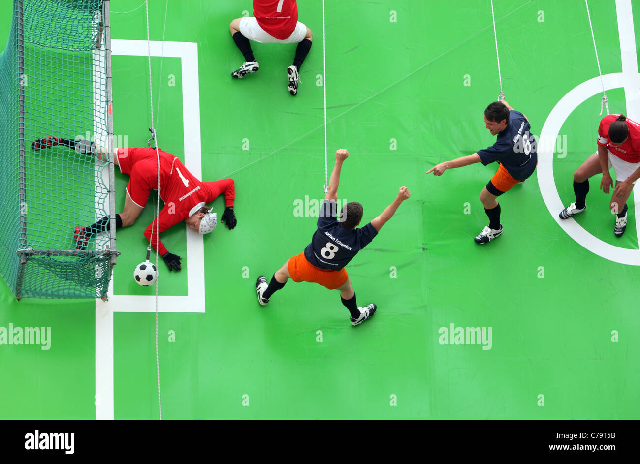 I giocatori di calcio appesi a funi, giocare a calcio su un campo verticale, Monaco di Baviera, Germania Foto Stock