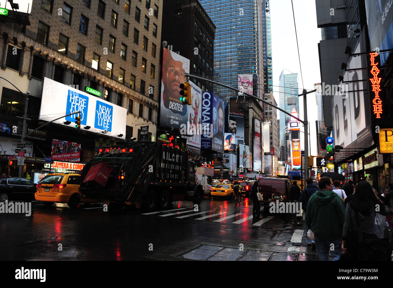 Piovosa asfalto bagnato reflectionsview vetture giallo taxi cestino carro neon di grattacieli, 7th Avenue, verso Times Square di New York City Foto Stock