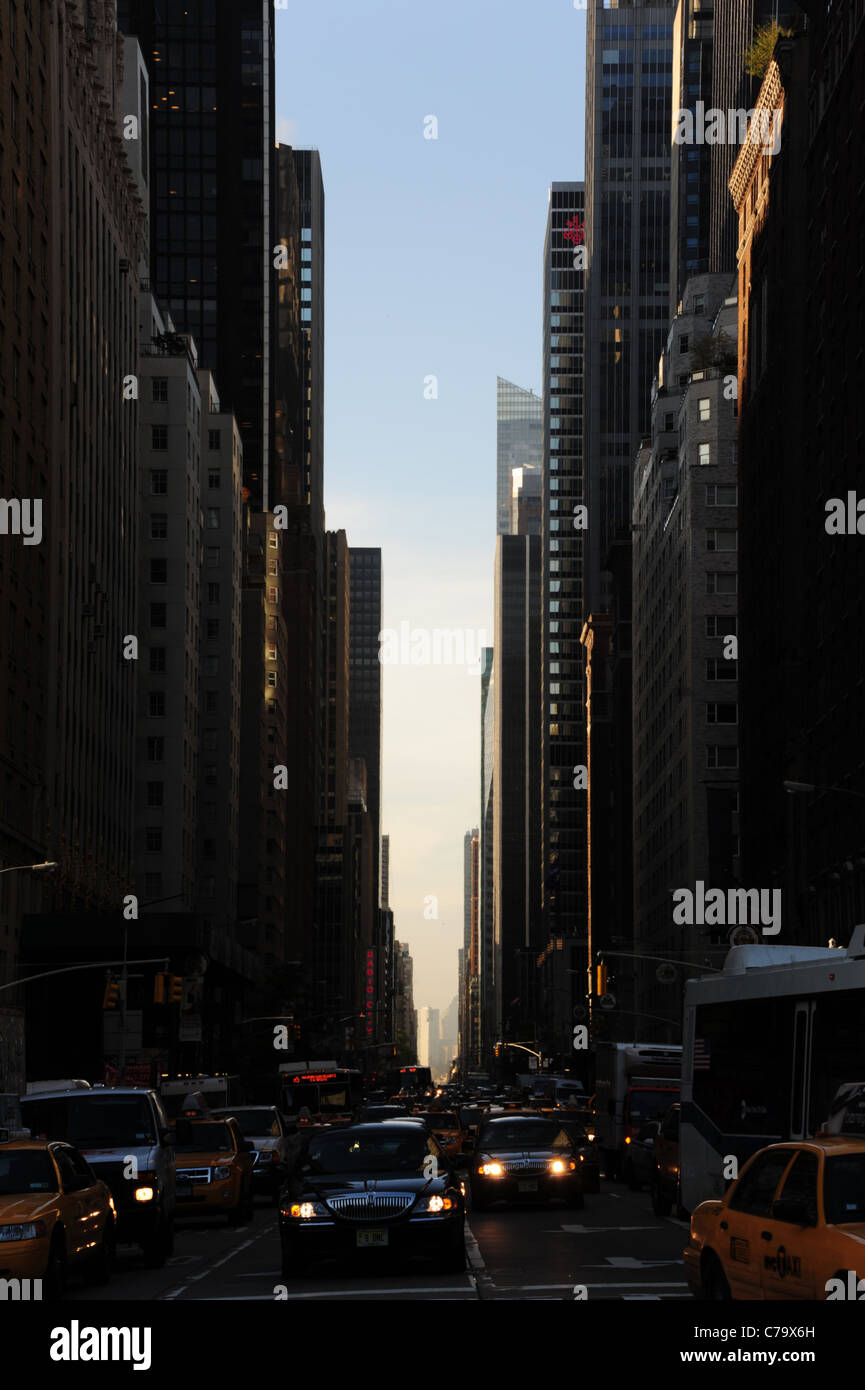 La mattina presto ritratto "Vicolo kyscraper' 6th Avenue, con il traffico in attesa alla giunzione con il Central Park South, New York , USA Foto Stock