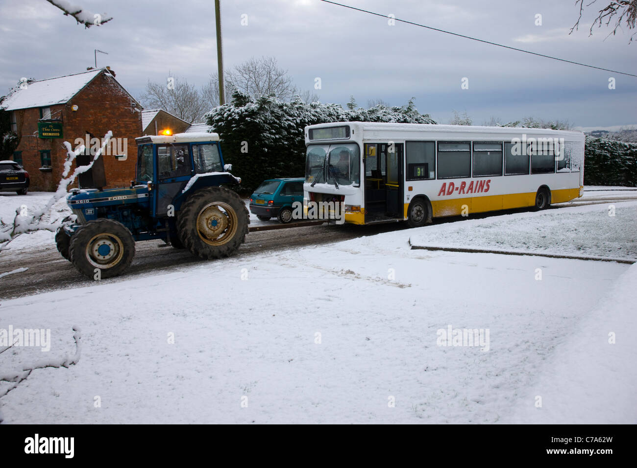 Un pullman è trainato attraverso la neve invernale da un trattore Foto Stock
