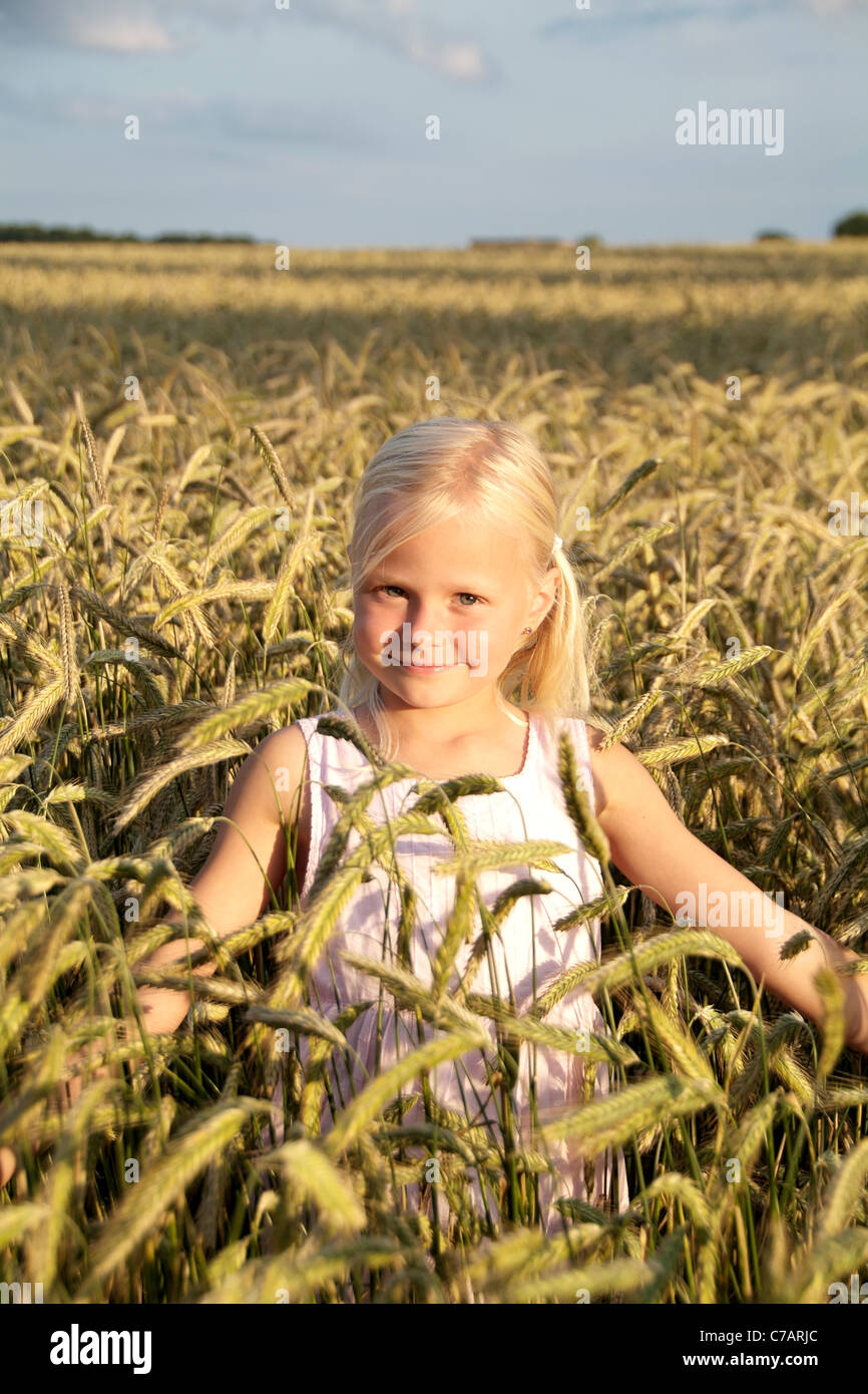 Ragazza 6 anni, indossando un abito in un campo di grano in estate, Eyendorf, Bassa Sassonia, Germania, Europa Foto Stock