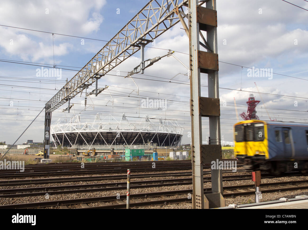 Moto sfocata commuter train velocità passato allo stadio Olimpico di Stratford, Londra Foto Stock