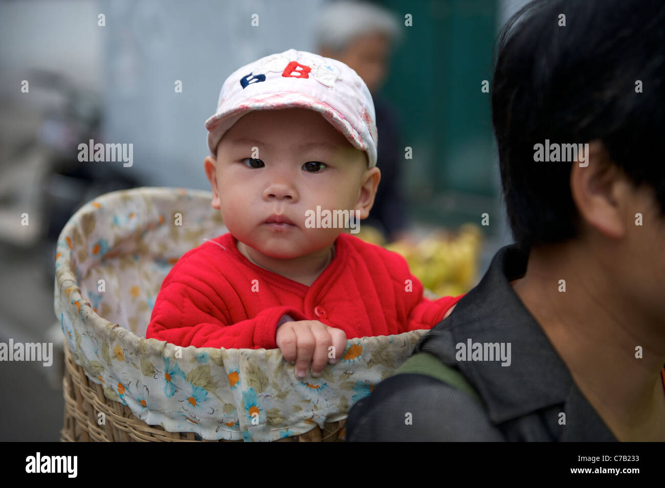 Cinese donna migrante che porta un bambino sulla schiena con un cesto di bambù a Pechino in Cina.16-set-2011 Foto Stock