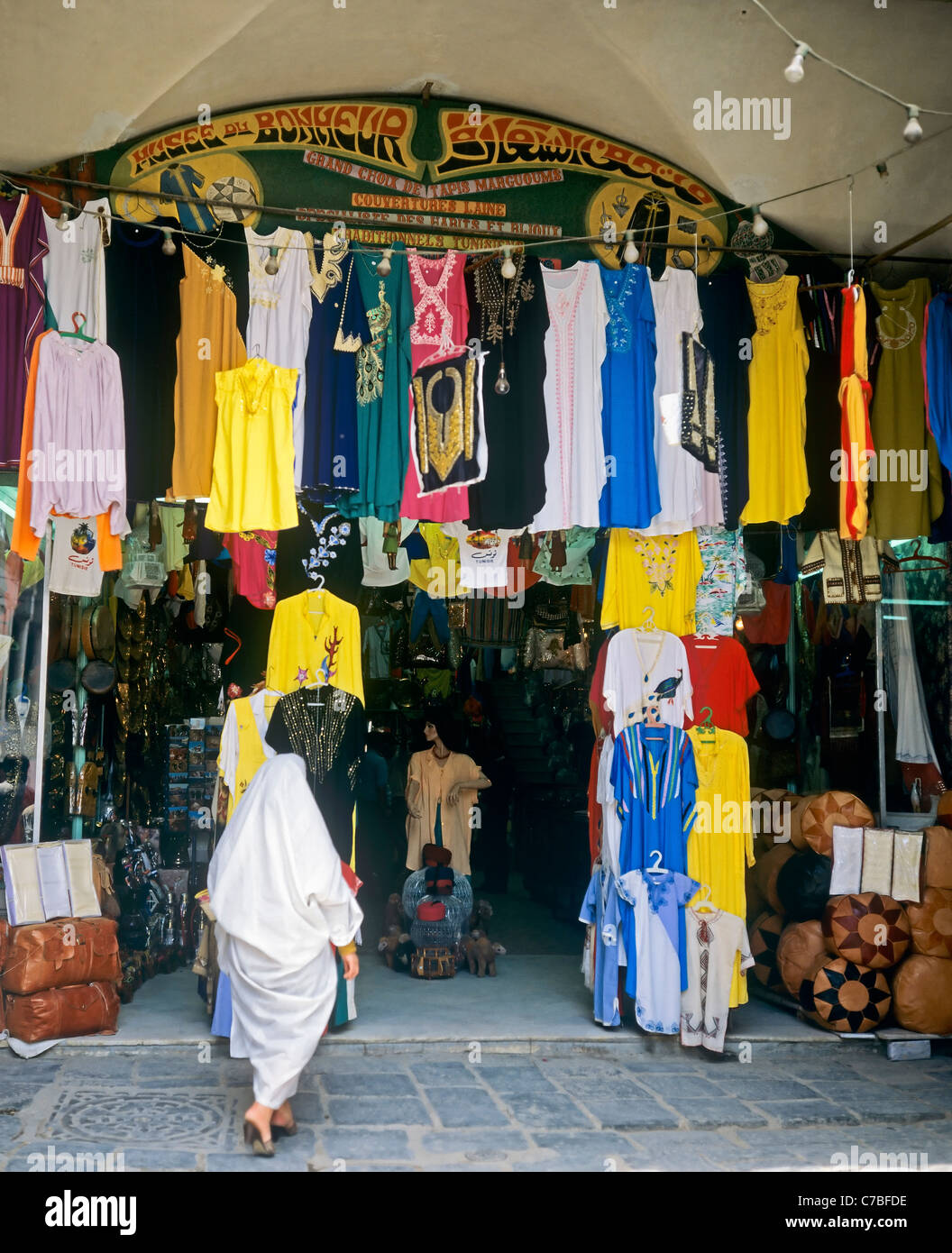 A Tunisi, Tunisia, Nord Africa, la vecchia Medina, Donna vestita con un bianco jellaba shopping nei Souk, Foto Stock