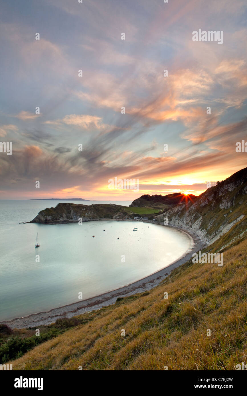 Una vista di Lulworth Cove, parte della Jurassic Coast in Dorset al tramonto con Portland Bill in distanza Foto Stock