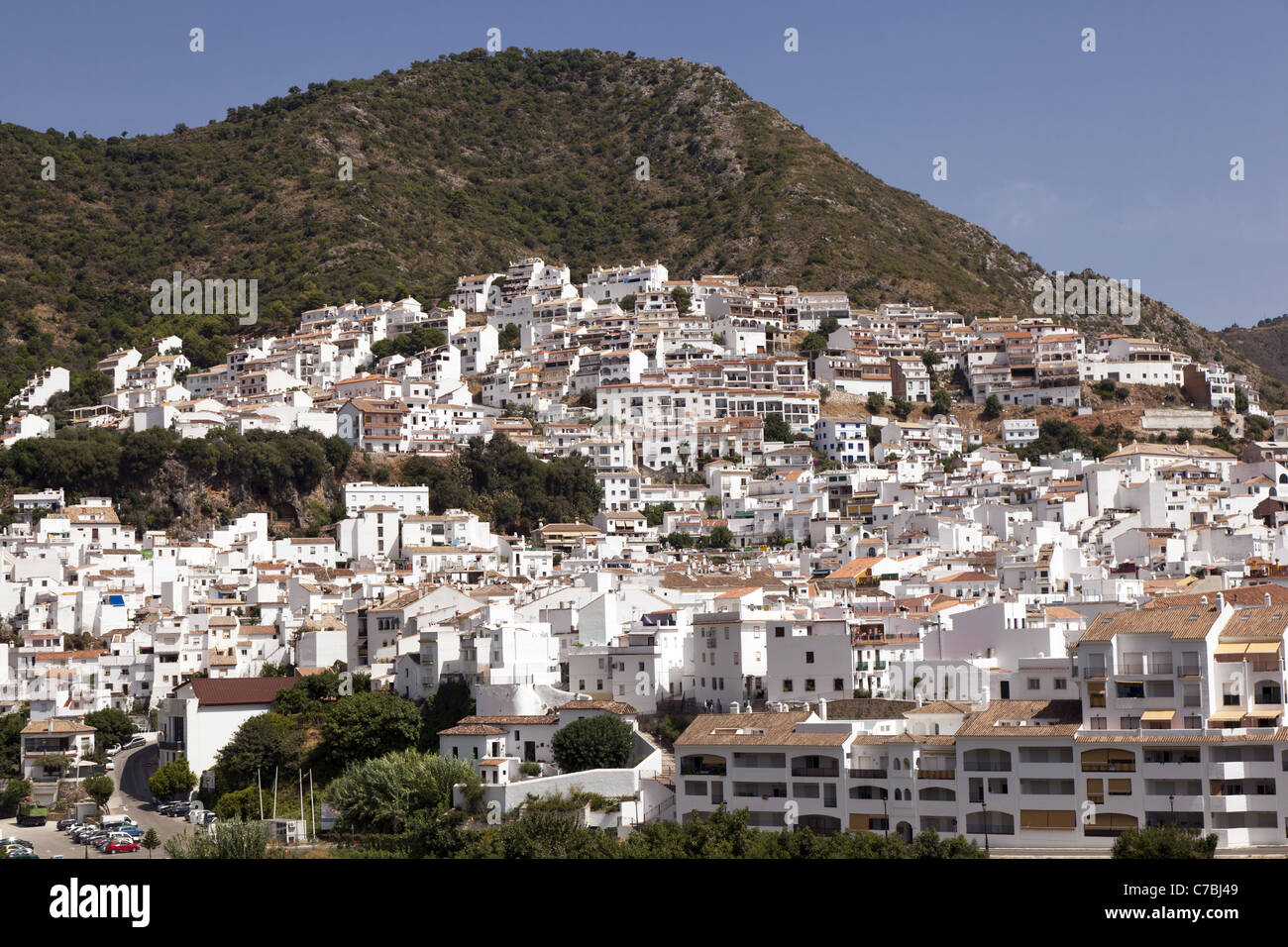 Vista su tutta la valle a Ojen in Andalusia, Spagna, mostrando il bianco degli edifici di questo tipico di collina villaggio spagnolo. Foto Stock