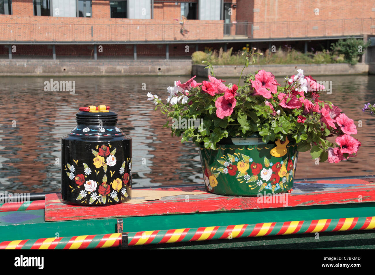 Brighly dipinto di vasi di fiori su un canal boat ormeggiato sul fiume Avon a Stratford Upon Avon, Warwickshire, Inghilterra, Regno Unito. Foto Stock