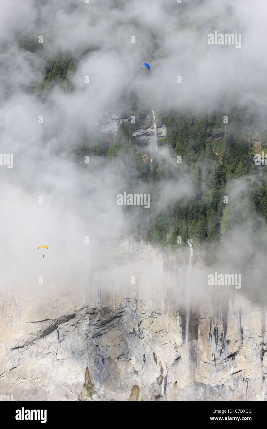 Due paracadutisti che si innalzano per la magnifica cascata Staubbachfall sopra la Valle Lauterbrunnen. Berna, Svizzera. Foto Stock